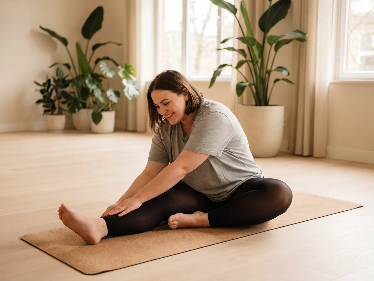 Frau mit Kurven bei Dehnübungen auf der Yogamatte in blickdichter Strumpfhose ohne Fuß