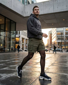 Transparente Classic 20 Herrenstrumpfhose in Schwarz, glatt anliegend an männlichen Beinen Editorial