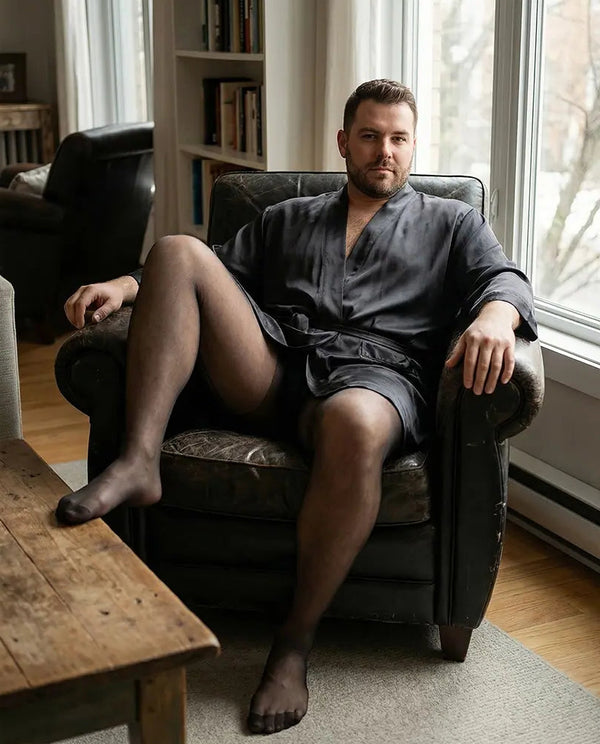 Transparente Classic 20 Herrenstrumpfhose in Schwarz, glatt anliegend an männlichen Beinen Editorial